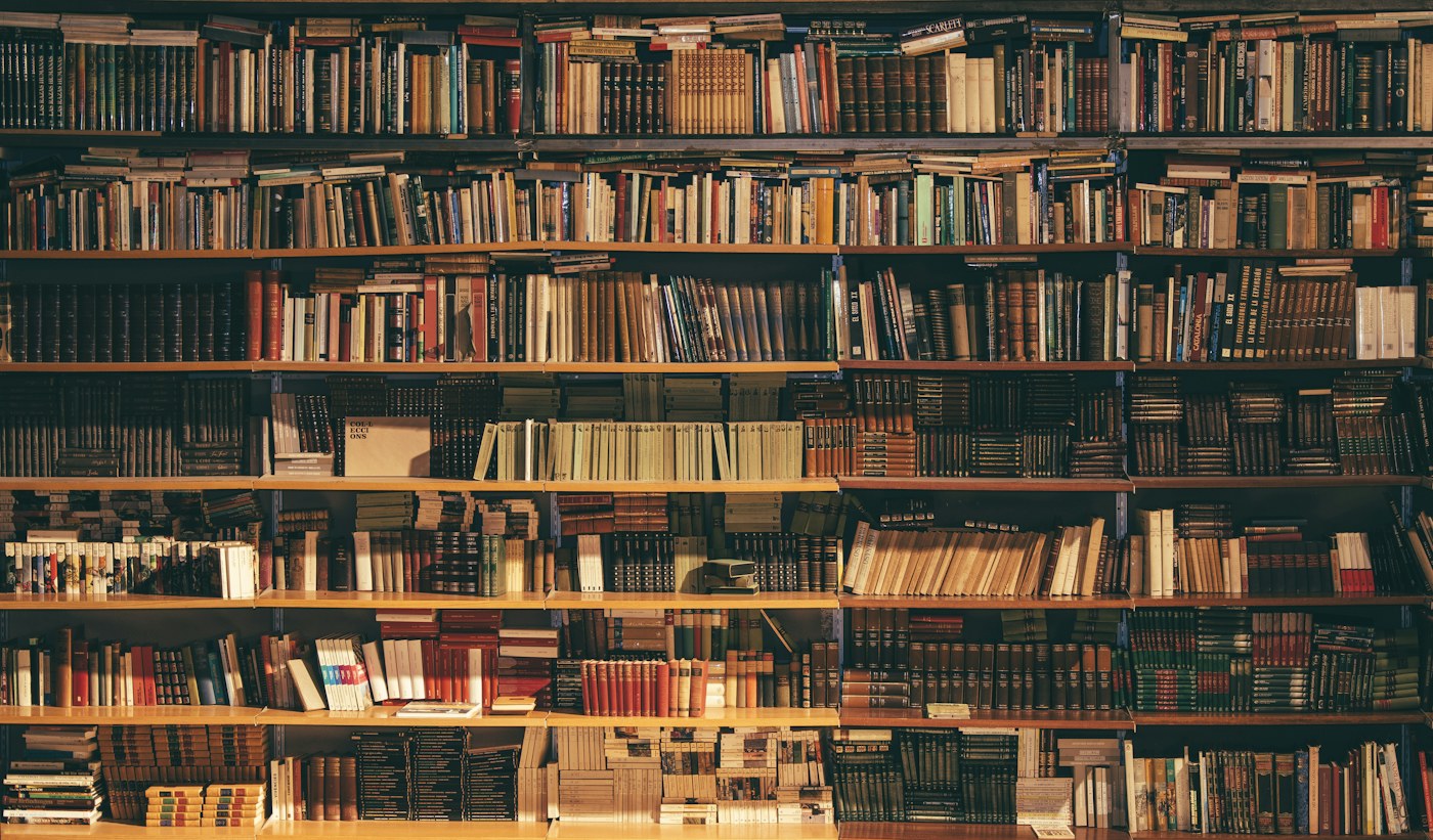 Rows of well-loved old books lining a traditional bookcase