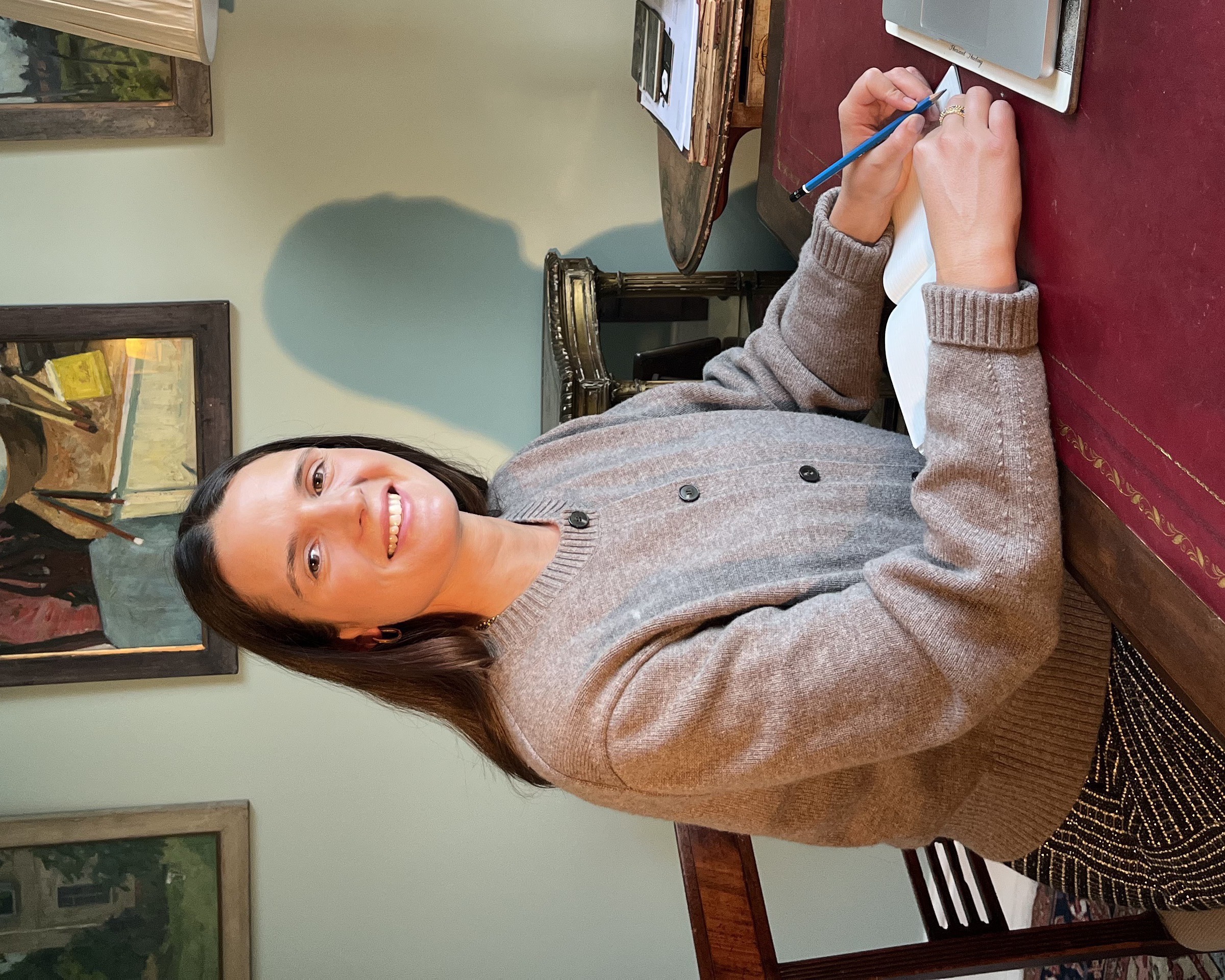 Ella writing in a notebook at a desk